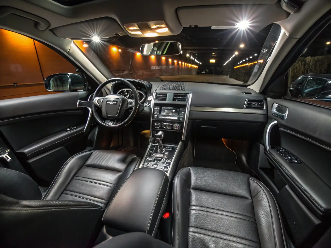 A close-up shot of a car's interior, highlighting the clean and conditioned leather seats, spotless dashboard, and meticulously vacuumed carpets, demonstrating the thoroughness of the interior detailing service.